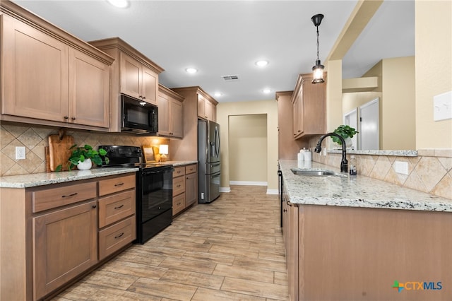 kitchen featuring black appliances, light stone countertops, pendant lighting, sink, and light hardwood / wood-style flooring