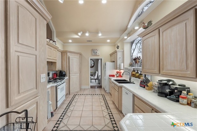 kitchen with tile countertops, white appliances, sink, light brown cabinetry, and light tile patterned flooring