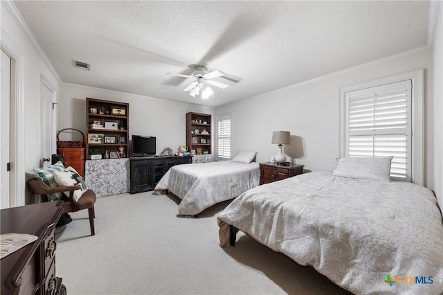 bedroom featuring a textured ceiling, ceiling fan, crown molding, and light carpet