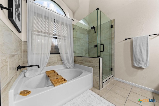 bathroom with a stall shower, a garden tub, baseboards, and tile patterned floors