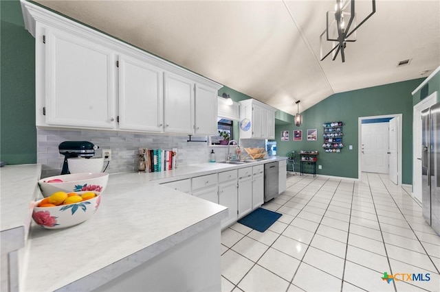 kitchen featuring lofted ceiling, sink, light tile patterned floors, dishwasher, and white cabinetry