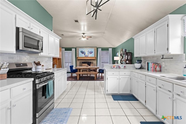 kitchen featuring stainless steel appliances, light tile patterned floors, white cabinets, and ceiling fan