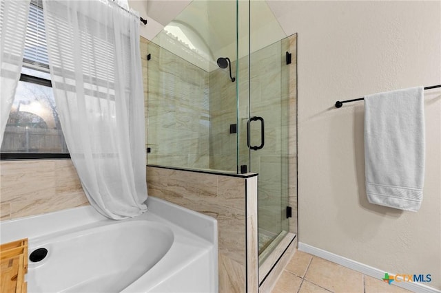 full bathroom featuring a stall shower, a garden tub, baseboards, and tile patterned floors