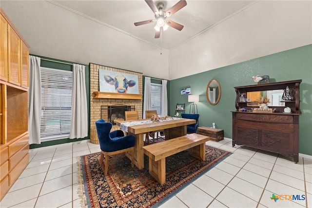 dining room featuring a fireplace, ceiling fan, and light tile patterned flooring