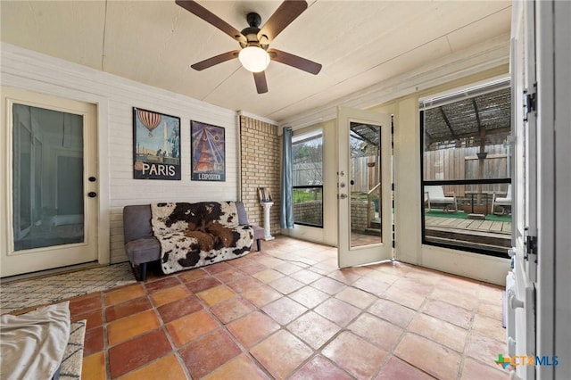 unfurnished sunroom with ceiling fan