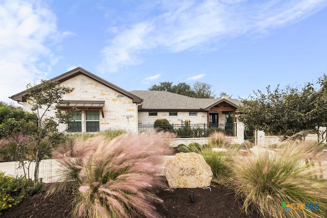 view of front of home with fence and stone siding