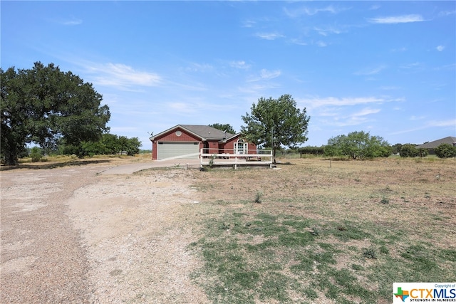 view of front of home with a garage and a rural view