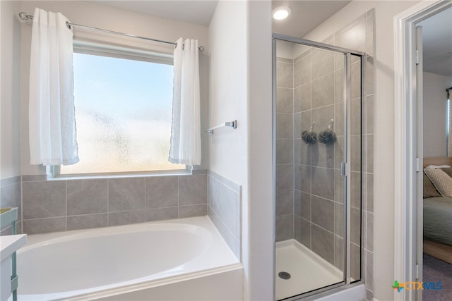 ensuite bathroom with vanity, ensuite bath, a bath, and a stall shower
