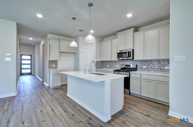 kitchen featuring sink, white cabinets, appliances with stainless steel finishes, and light wood-type flooring