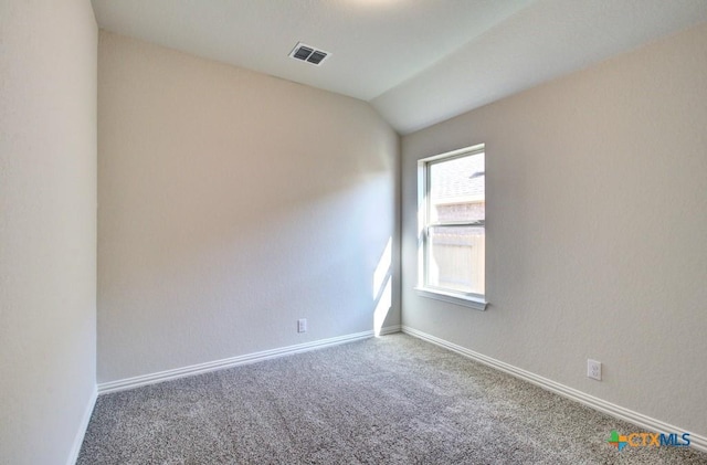 empty room featuring lofted ceiling and carpet floors