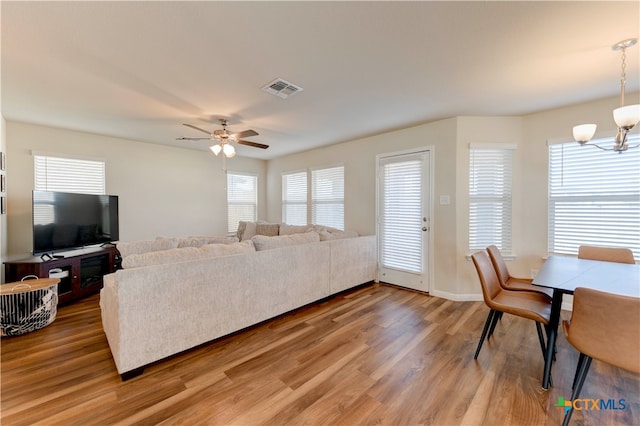 living room featuring wood-type flooring and ceiling fan with notable chandelier