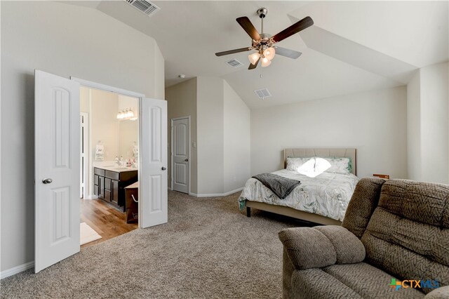 carpeted bedroom with connected bathroom, sink, vaulted ceiling, and ceiling fan