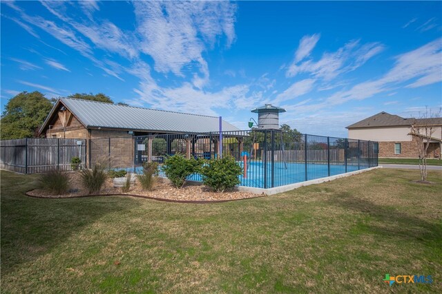 view of pool featuring a lawn