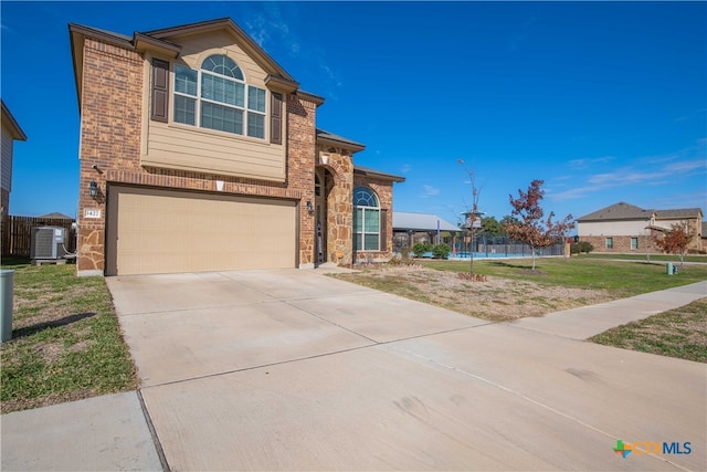 view of front facade featuring central AC unit, a garage, a front yard, and a trampoline