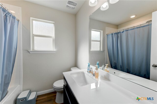 full bathroom featuring toilet, shower / tub combo with curtain, vanity, and wood-type flooring