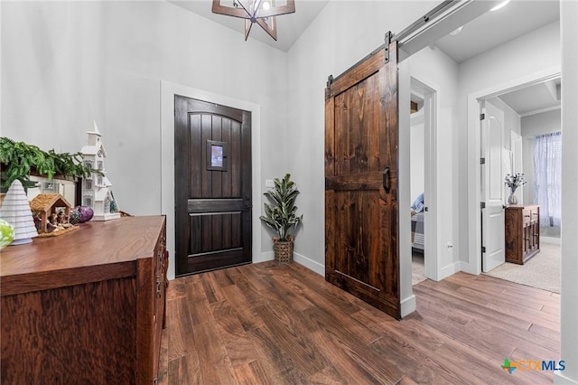 foyer featuring a barn door and dark wood-type flooring