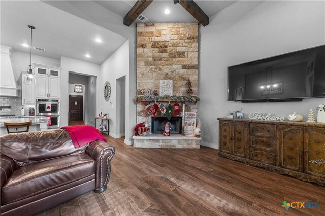 living room with beamed ceiling, dark hardwood / wood-style floors, and a fireplace