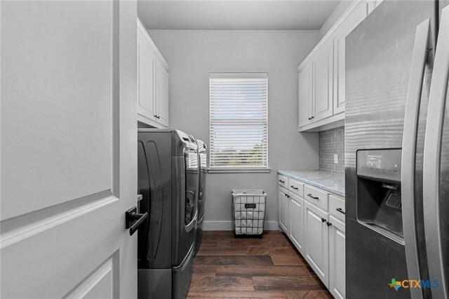 laundry area with washer and clothes dryer, dark hardwood / wood-style floors, and cabinets