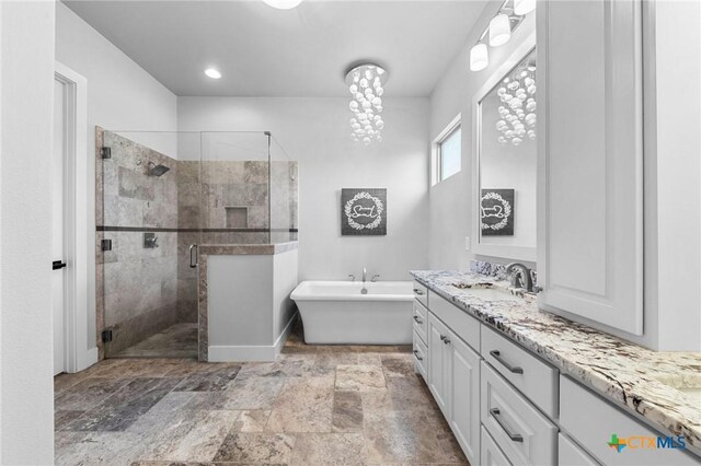 bathroom featuring plus walk in shower and vanity