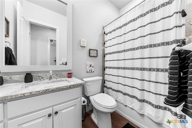 full bathroom with hardwood / wood-style floors, vanity, toilet, and shower / bath combo with shower curtain