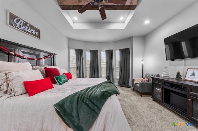 carpeted bedroom featuring beam ceiling, ceiling fan, and a tray ceiling