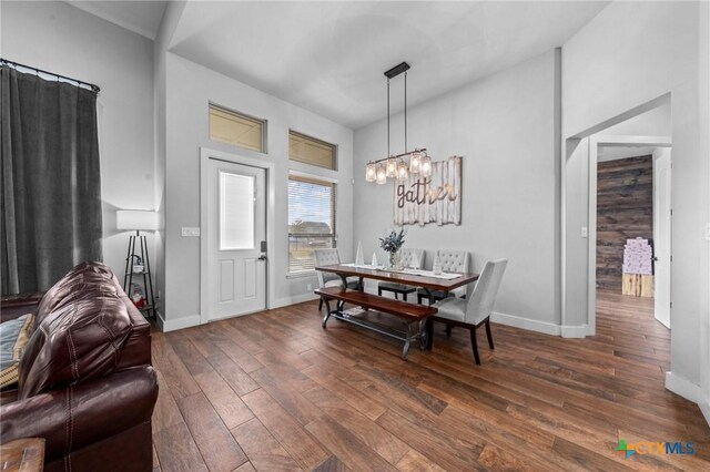 dining space with dark hardwood / wood-style flooring and a notable chandelier