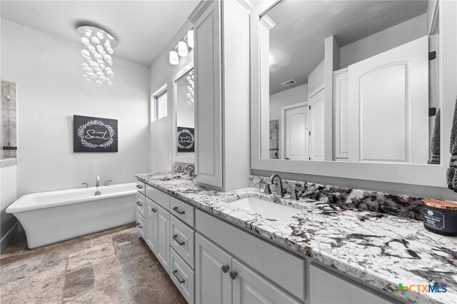 bathroom featuring a washtub and vanity