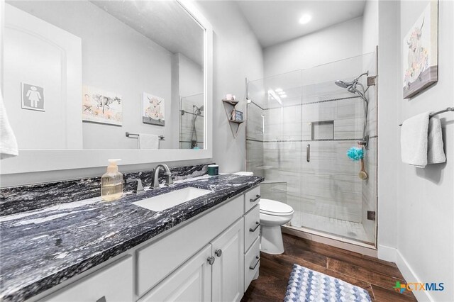 bathroom with vanity, hardwood / wood-style flooring, toilet, and walk in shower