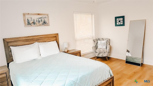 bedroom featuring wood finished floors and baseboards