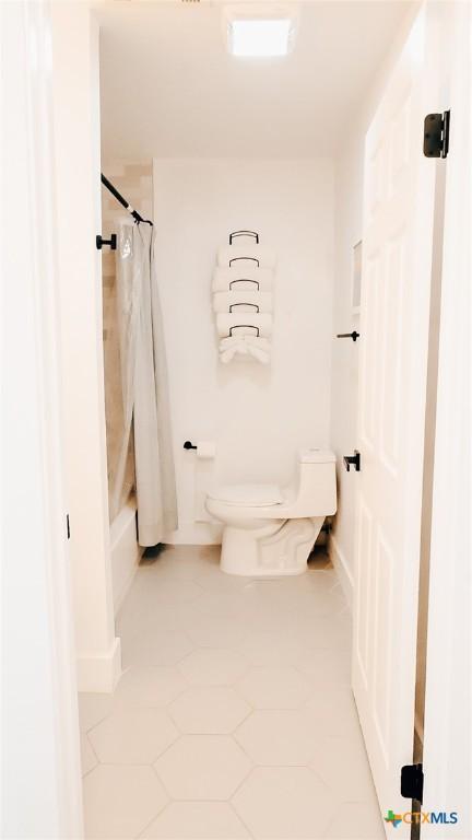 full bath with shower / bathtub combination with curtain and toilet