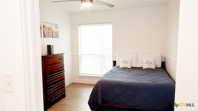 bedroom with light wood finished floors, multiple windows, and a ceiling fan