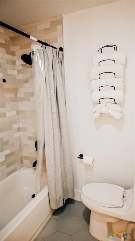 full bathroom with shower / bath combination with curtain, toilet, and tile patterned floors