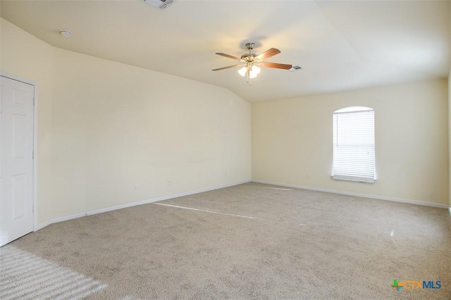 carpeted empty room with vaulted ceiling and ceiling fan