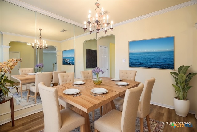 dining room featuring dark hardwood / wood-style flooring, crown molding, and a chandelier