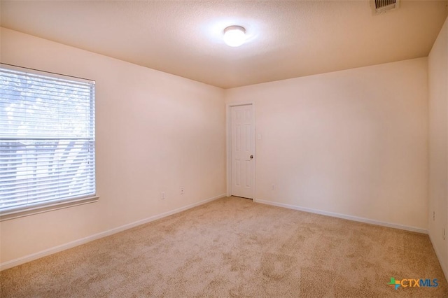 carpeted spare room featuring a textured ceiling