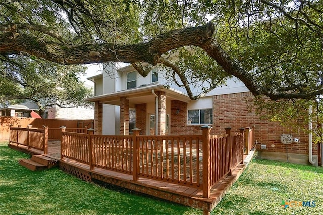 rear view of house with a yard and a deck