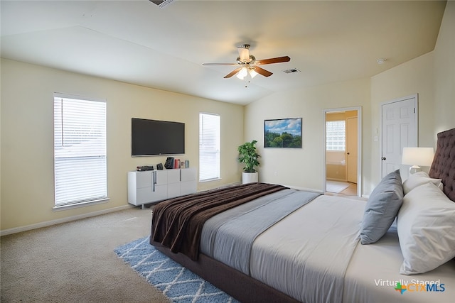 carpeted bedroom featuring multiple windows, lofted ceiling, connected bathroom, and ceiling fan