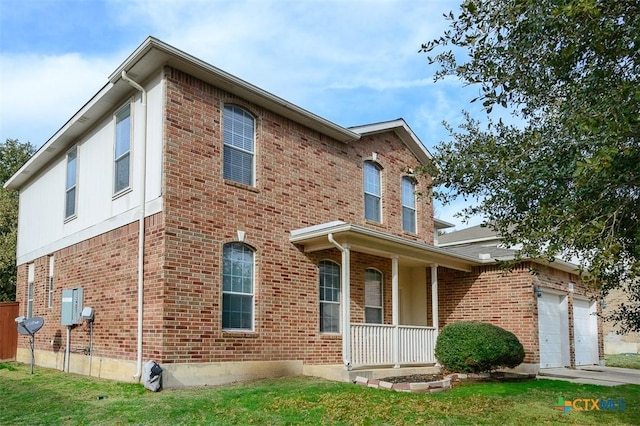 view of front of home featuring a porch, a garage, and a front yard