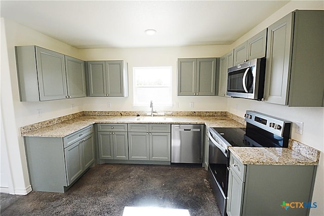 kitchen with appliances with stainless steel finishes, sink, and gray cabinetry