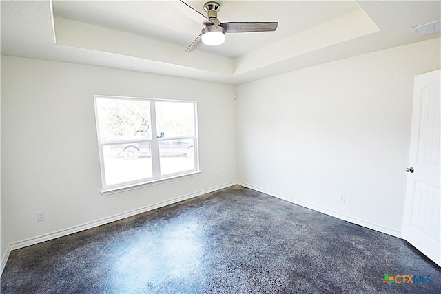 spare room featuring ceiling fan and a tray ceiling