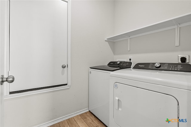 laundry room with separate washer and dryer and light hardwood / wood-style flooring