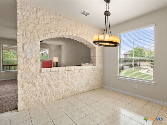 515 Secluded Grv, San Antonio, TX 78253 - unfurnished dining area with a chandelier, baseboards, tile patterned floors, and arched walkways