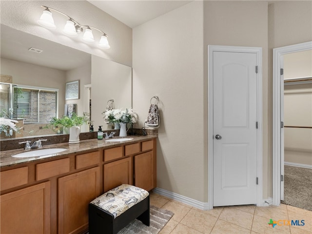 515 Secluded Grv, San Antonio, TX 78253 - bathroom with double vanity, tile patterned flooring, a spacious closet, a shower stall, and baseboards