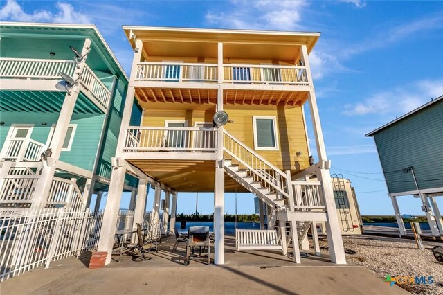 52 Fm 2031, Matagorda, TX 77457 - view of front of property with stairway, a balcony, and a patio area