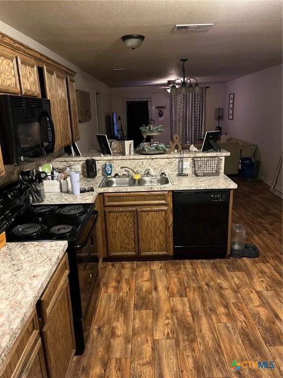 801AND803 S Live Oak St, Lampasas, TX 76550 - kitchen featuring black appliances, dark wood finished floors, brown cabinets, and a textured ceiling