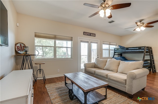 living room featuring dark wood-type flooring and ceiling fan