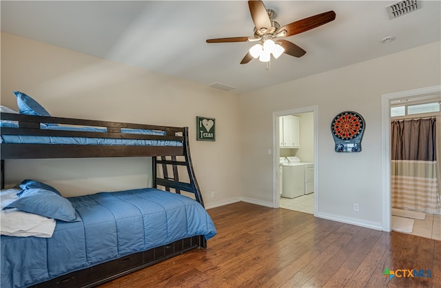 bedroom featuring ceiling fan, hardwood / wood-style flooring, washer and dryer, and ensuite bathroom