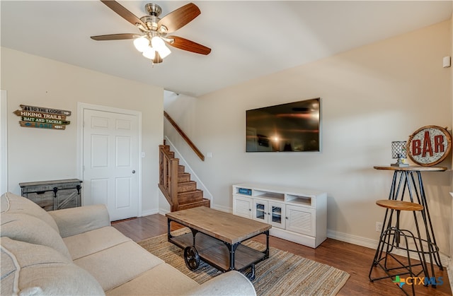 living room with ceiling fan and dark hardwood / wood-style flooring