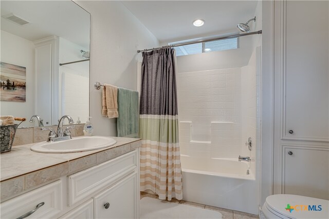 full bathroom featuring toilet, vanity, tile patterned floors, and shower / tub combo