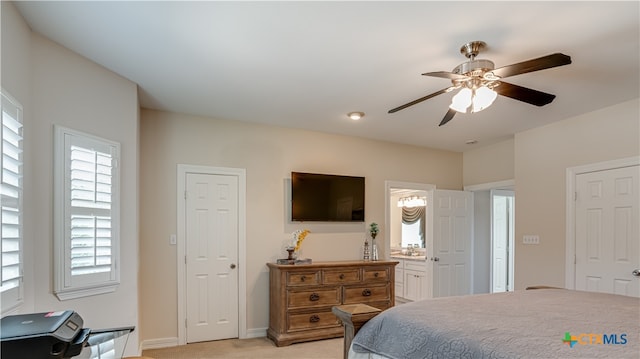 carpeted bedroom with ceiling fan and ensuite bath